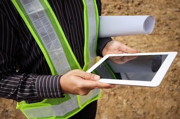 Engineers in hard hats and safety vests review digital schematics on a tablet at a partially completed construction site, with a large piece of heavy machinery in the background, symbolizing technological integration and progress in infrastructure development.