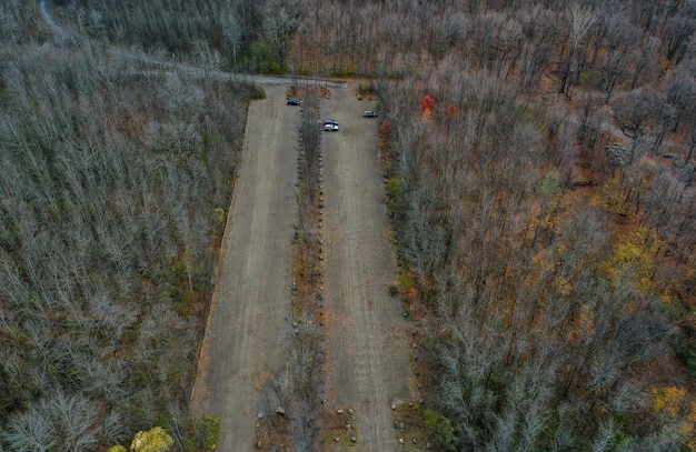 A drone shot capturing a US highway severely damaged by a recent flood, with large sections of asphalt washed away and emergency vehicles attempting to navigate the debris.