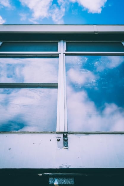 A detailed close-up of a weather-sealed window with hurricane shutters partially closed, showing robustness and preparedness.
