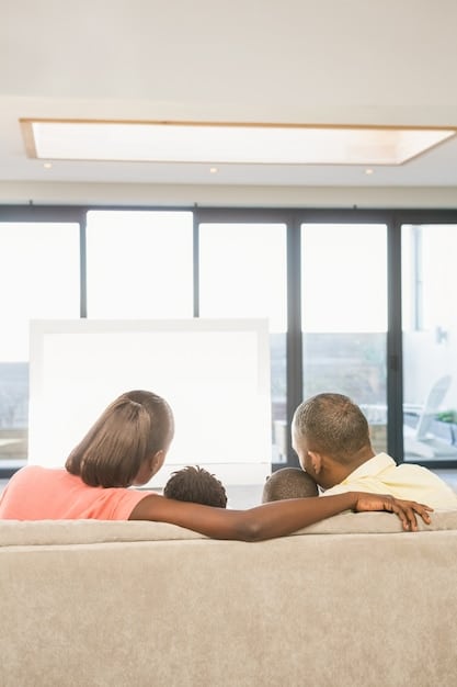 A family enjoying a comfortable temperature in their living room, with natural light streaming in, highlighting the consistent indoor climate provided by a modern HVAC system.