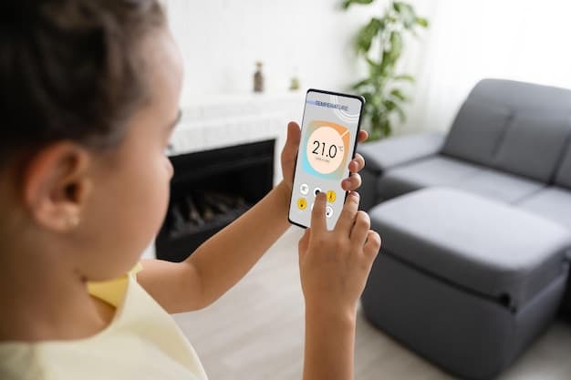 A close-up shot of a smartphone screen displaying a smart thermostat app interface, showing temperature settings, energy usage charts, and remote control options, with a blurred modern living room in the background.